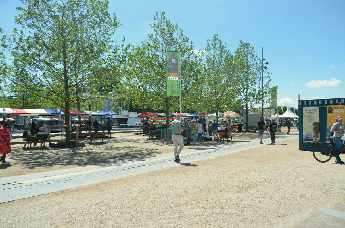 A festival market in an Amsterdam park with canopied stalls